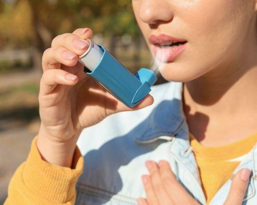 Female using inhaler for bronchial asthma